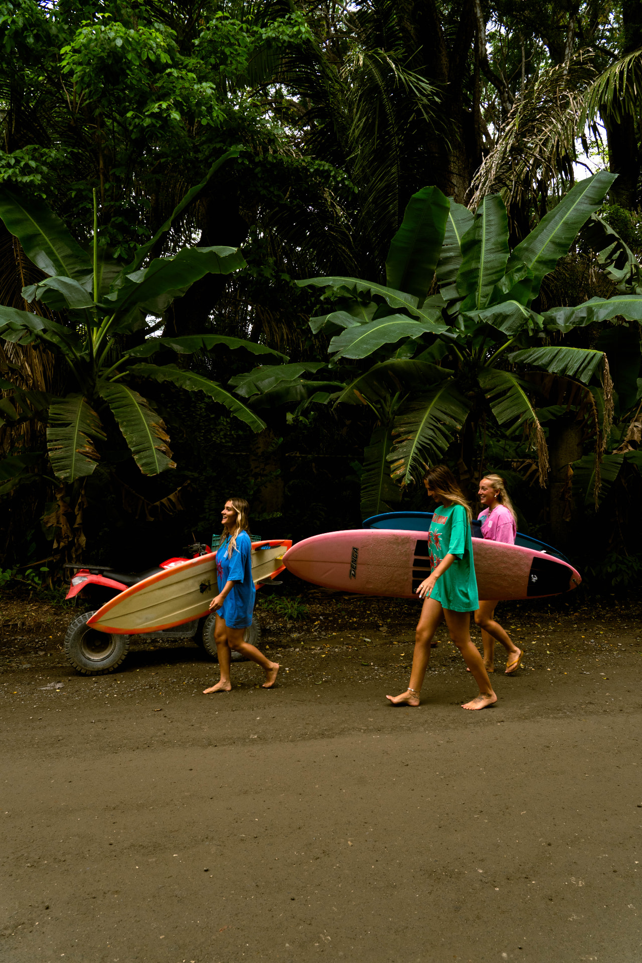 Friends carrying surfboards to the beach in Santa Teresa, Costa Rica
