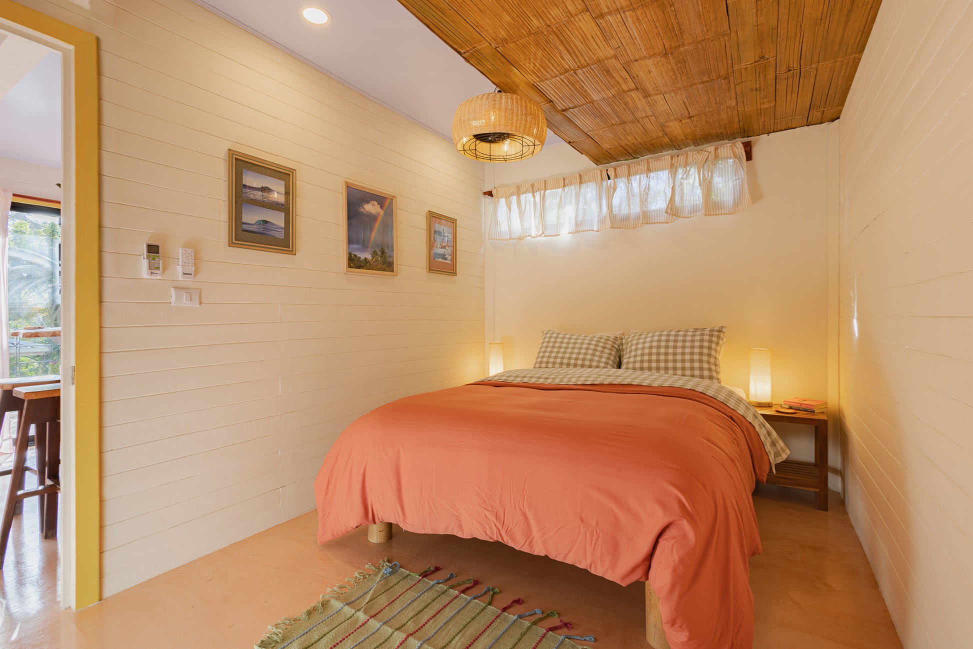 Apartment Piña — Bedroom with double bed, coral bedding and wooden ceiling