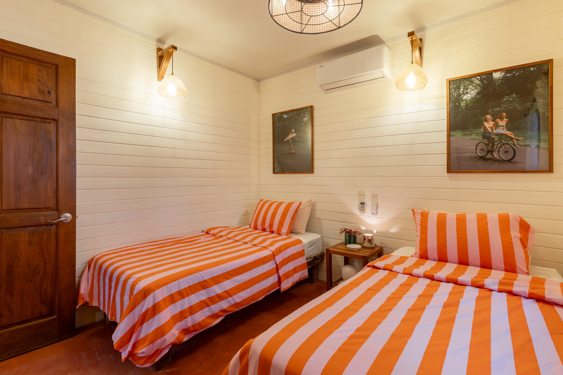 Apartment Papaya — Twin bedroom with wooden door and bicycle artwork