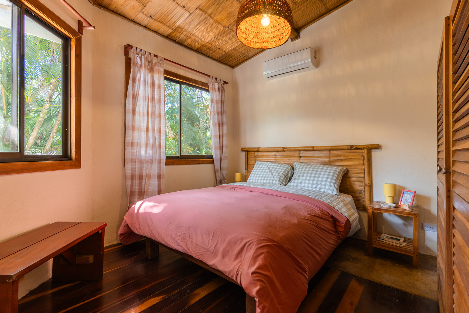Apartment Sandía — Bedroom with double bed, wooden headboard and jungle-view windows