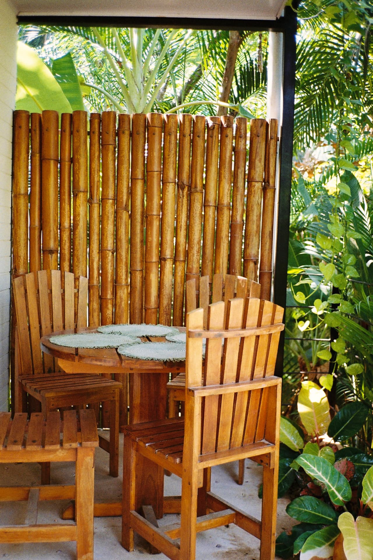 Wooden table and chairs on a bamboo-screened patio