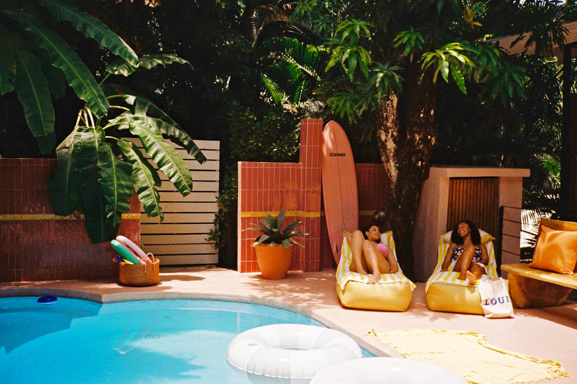 Loungers and a surfboard by the pool