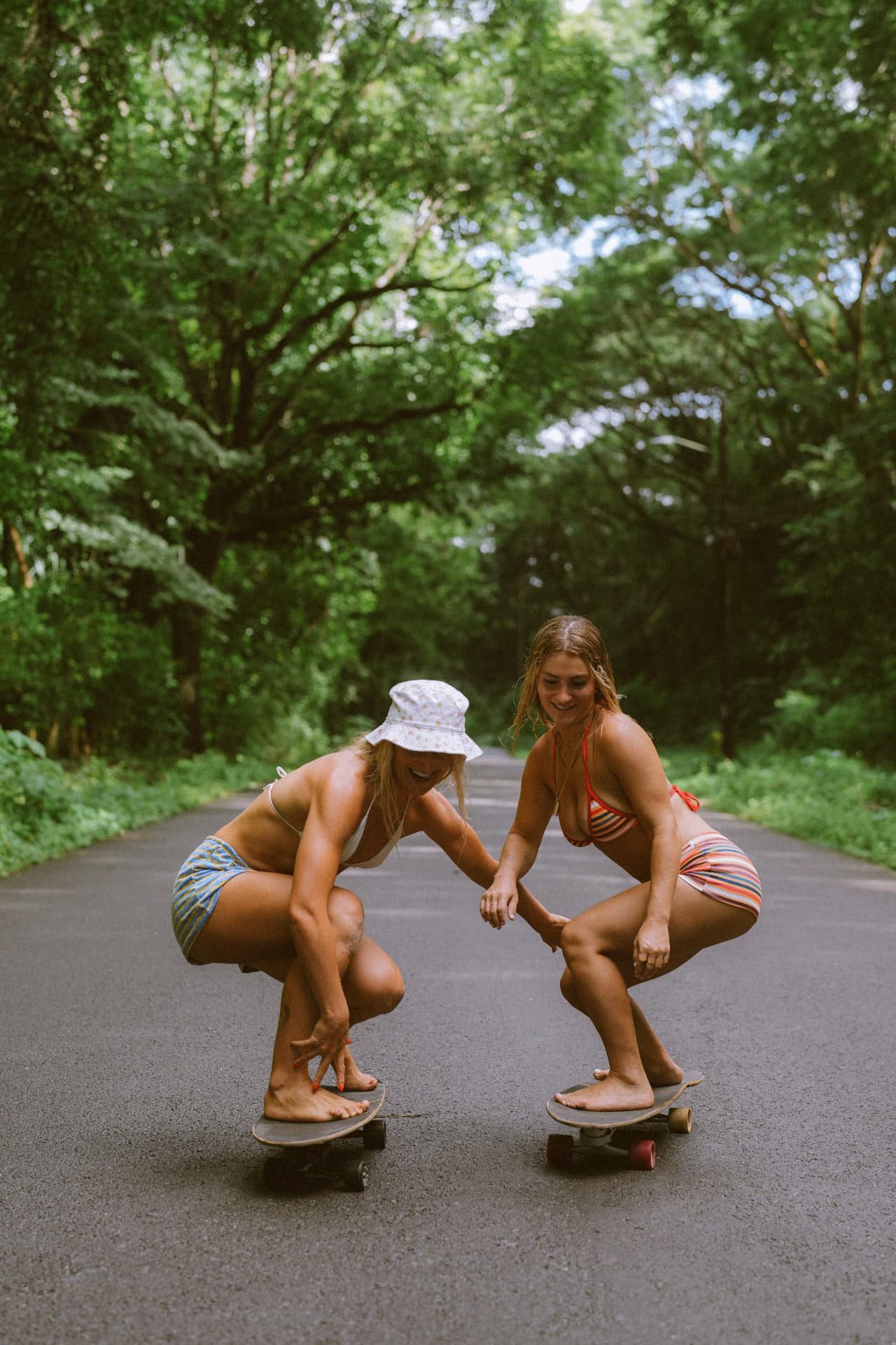 Two friends skateboarding down a jungle road