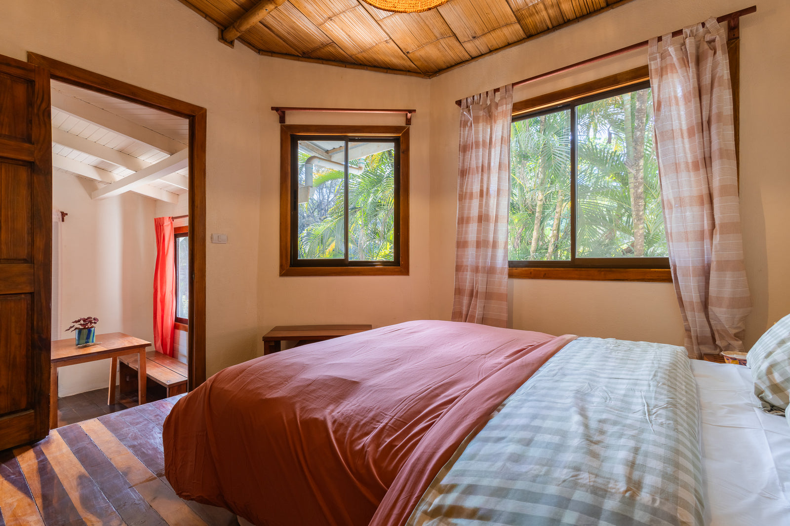 Apartment Sandía — Bedroom with double bed and windows onto tropical greenery