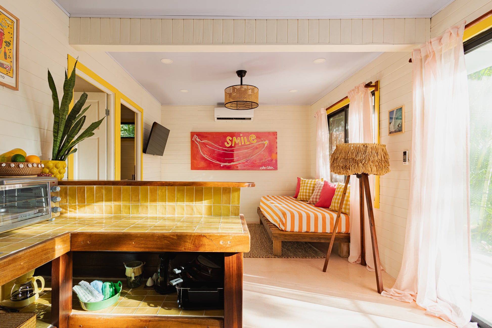 Apartment Piña — Kitchen and breakfast bar with yellow tile, living area behind