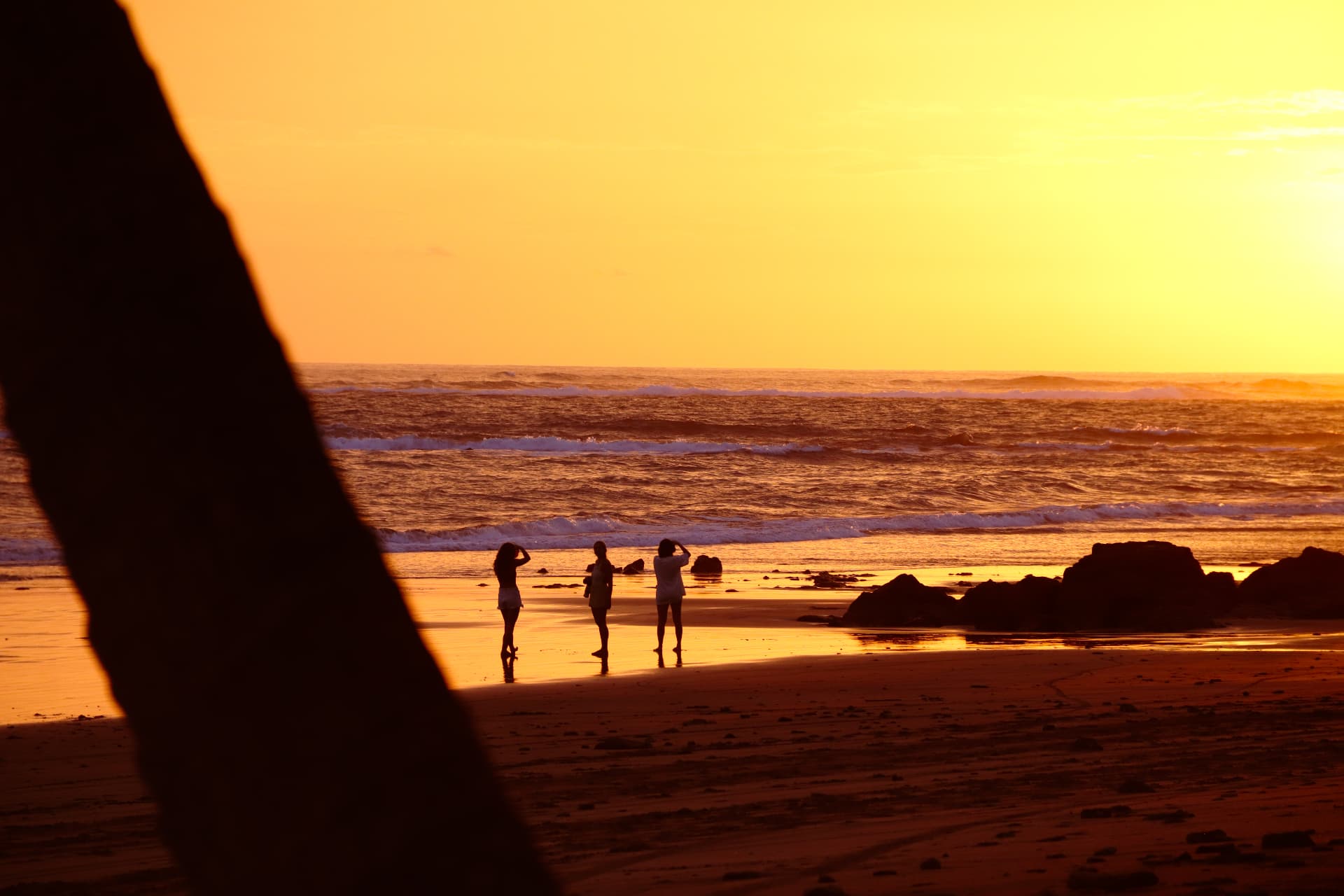 Golden sunset on the beach with friends at the water's edge