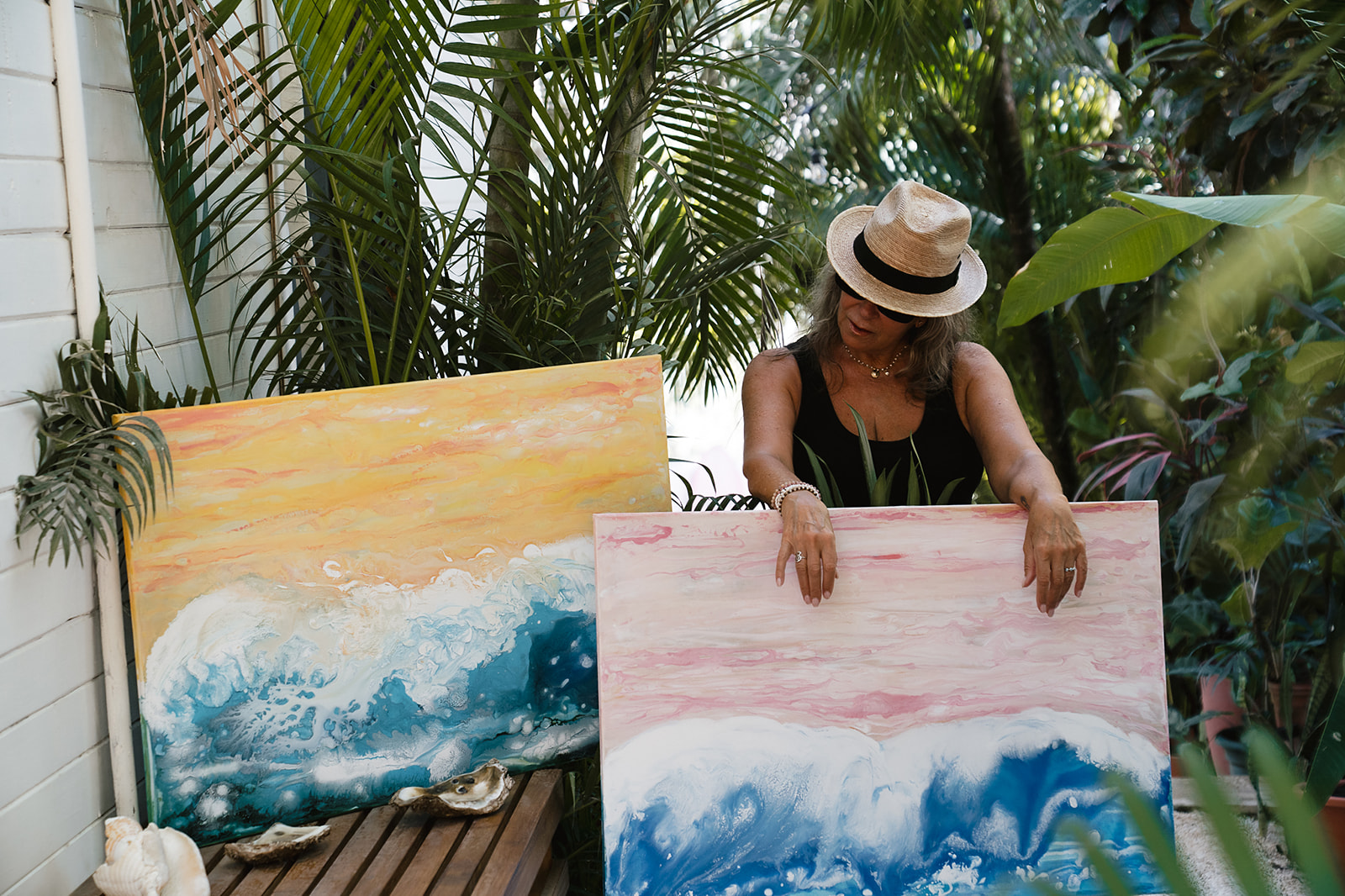 Lori Burke arranging her ocean paintings in the garden