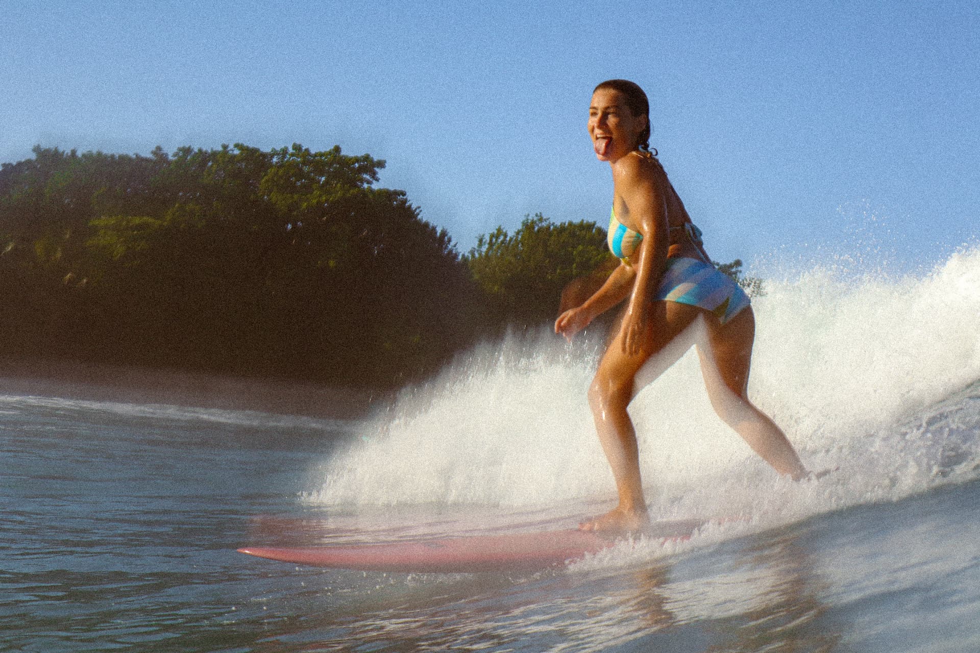 A surfer riding a wave with a big smile