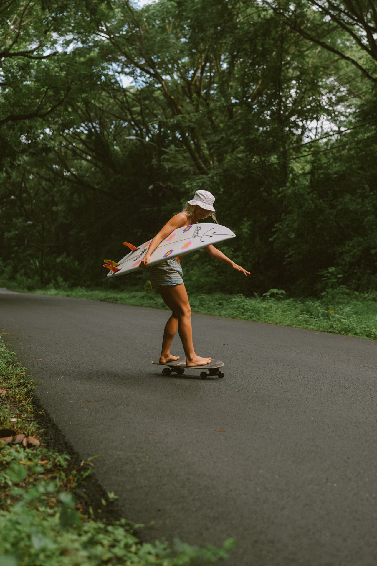 A local surfer skateboarding through the green roads of Santa Teresa